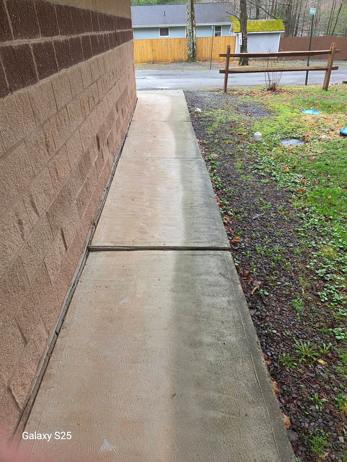Bright clean concrete sidewalk beside a freshly washed retaining wall